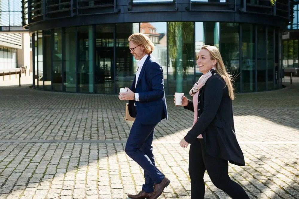 Personer går udenfor med en kop kaffe